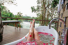 Badewanne mit Rosenblüten auf der privaten Terrasse
