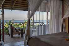 Blue Zebra Island Lodge, Schlafzimmer mit Himmelbett, Blick auf Terrasse