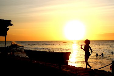 Frau im Sonnenuntergang am Strand