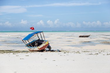 Ein Mann arbeitet an seinem Boot am Strand