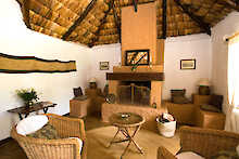 Lounge-Bereich mit Kamin und Sitzgelegenheiten in der Arusha Safari Lodge