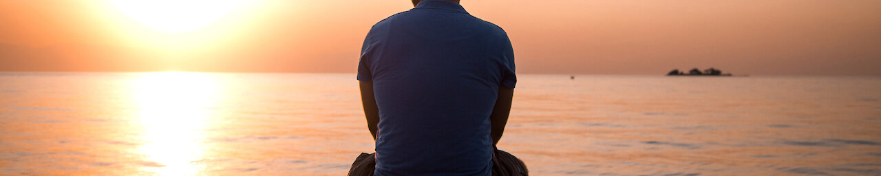 Mann auf Boot mit Sonnenuntergang