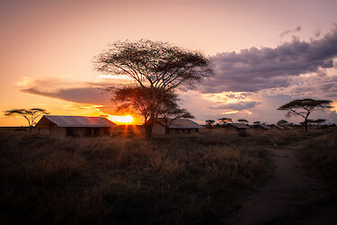 Blick auf die Mawe Tented Camp Zelte in Weitaufnahme mit Sonnenuntergang