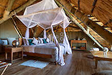Zimmer mit Himmelbett im Ikuka Safari Camp