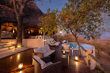 Sitzecke am Pool bei abendlicher Beleuchtung im Ikuka Safari Camp