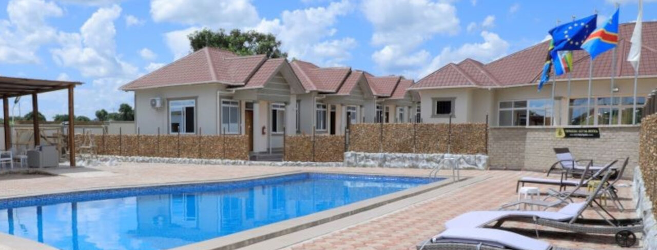 Nangero Royal Hotel mit Außenpool und Liegen neben den Unterkünften