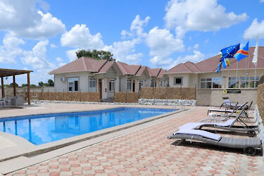 Nangero Royal Hotel mit Außenpool und Liegen neben den Unterkünften