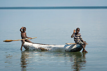 Winkende Kinder in einem Kanu auf dem Malawisee