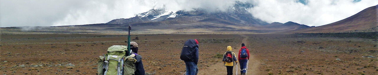 Wanderer mit Rucksäcken auf der Route zum Kilimandscharo