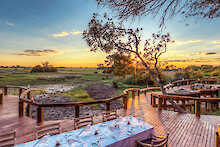 Camp Okavango Sonnenuntergang am Holzdeck mit gedeckten Tisch