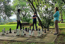 Riesiges Schachbrett im Garten mit drei Spielern