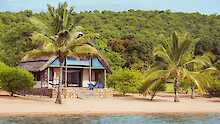 Tanganyika Lake Shore Lodge Chalet umgeben von Palmen
