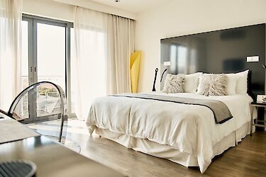 dysART Boutique Hotel - Südafrika, Kapstadt. Zimmer mit Doppelbett, Schreibtisch mit Blick zum Balkon.