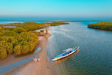 Luftaufnahme des Sine-Saloum-Deltas mit einem Boot auf dem Fluss