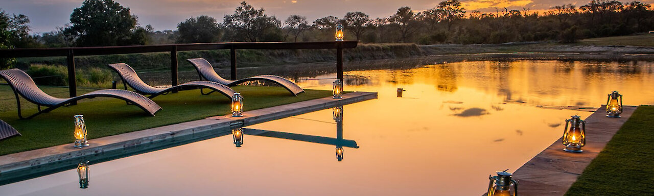 Arathusa Safari Lodge - Infinity Pool mit Blick auf Wasserloch und Sonnenuntergang. Südafrika