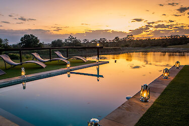 Arathusa Safari Lodge - Infinity Pool mit Blick auf Wasserloch und Sonnenuntergang. Südafrika
