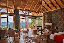 Nkuringo Bwindi Gorilla Lodge Rukundo Suite Doppelbett und Sitzgelegenheiten mit Blick zur Terrasse