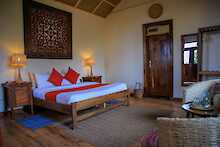 Nkuringo Bwindi Gorilla Lodge Schlafzimmer mit Doppelbett und Rattanmöbel