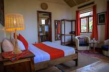 Nkuringo Bwindi Gorilla Lodge Schlafzimmer mit Doppelbett und Nachttischlampen und Blick zum Fenster