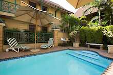 Court Classique Suite Hotel Pool mit Sonnenliegen und Sonnenschirm