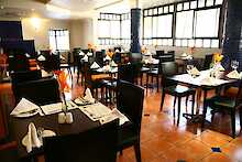 Court Classique Suite Hotel Orange Restaurant mit gedeckten Tischen und Sitzgelegenheiten