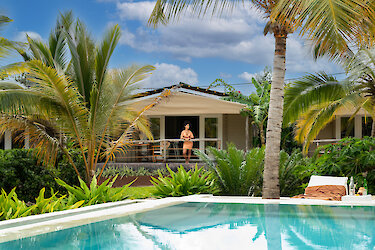 La Luna Suite Apartment mit Ausblick auf Pool umgeben von grüner Natur und Palmen