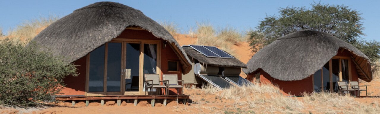 Aussicht auf die Dunes Camp Unterkünfte in den Hügeln und sandigem Boden