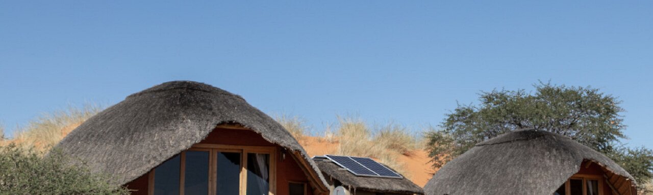 Aussicht auf die Dunes Camp Unterkünfte in den Hügeln und sandigem Boden