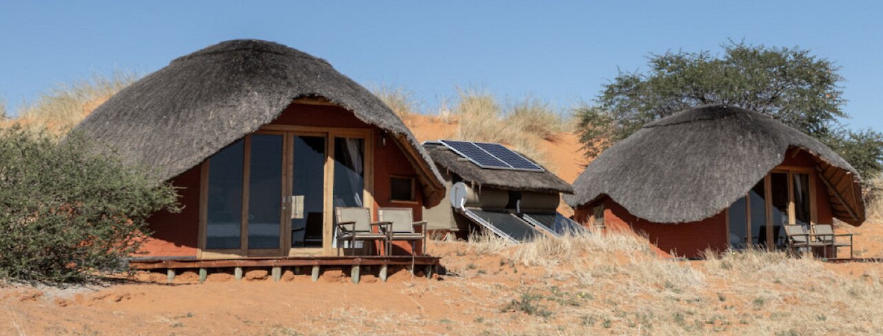 Aussicht auf die Dunes Camp Unterkünfte in den Hügeln und sandigem Boden
