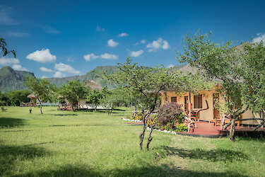 Eingang zu der Maasai Giraffe Eco Lodge mit grüner Wiese