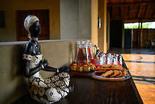 Snacks und Getränke neben die afrikanische Statue der Chikunto Safari Lodge