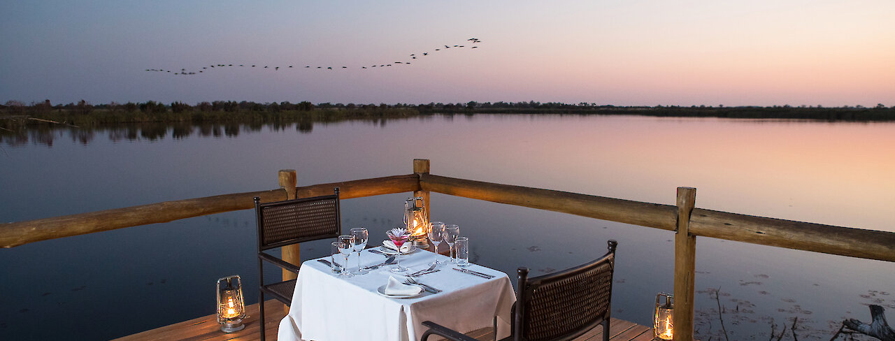 Abendessen im Außenbereich der Xugana Island Lodge mit Blick zum See