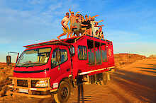 Menschen stehen auf dem Dach des Safari Trucks