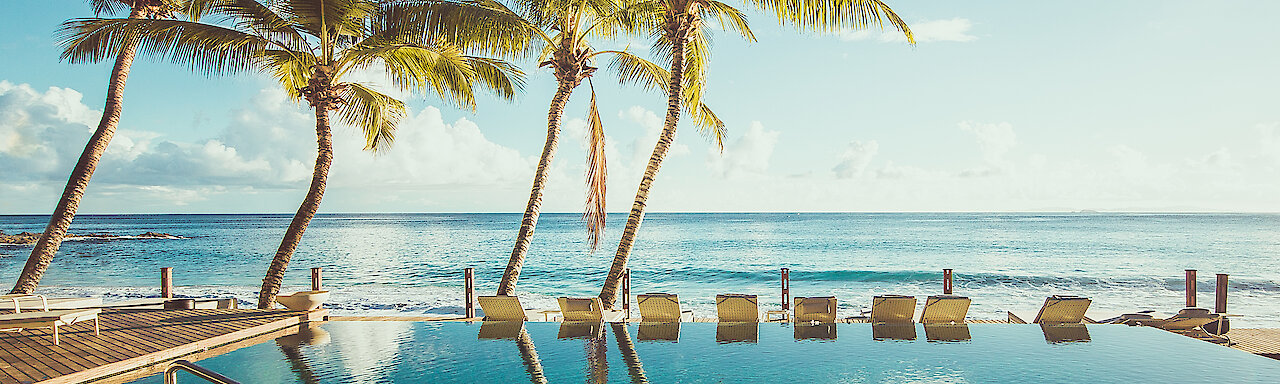 Pool mit Blick auf das Meer des Carana Beach Hotels