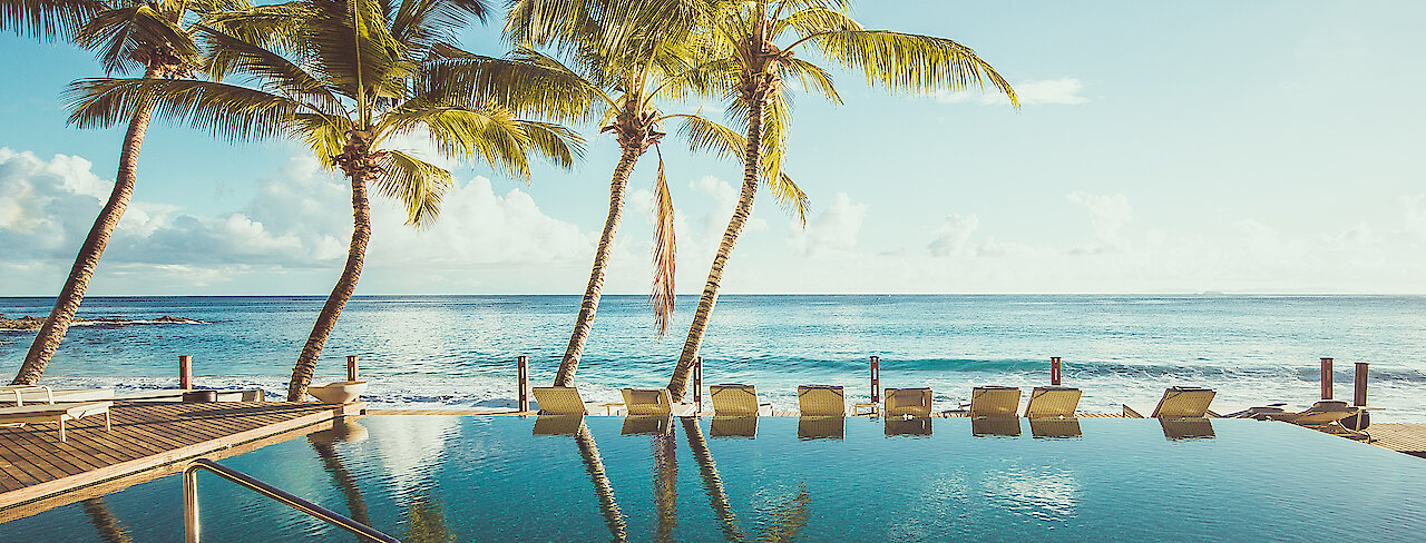 Pool mit Blick auf das Meer des Carana Beach Hotels