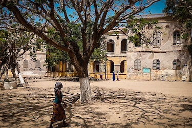 Bewohnerin läuft unter Bäumen lang auf Gorée