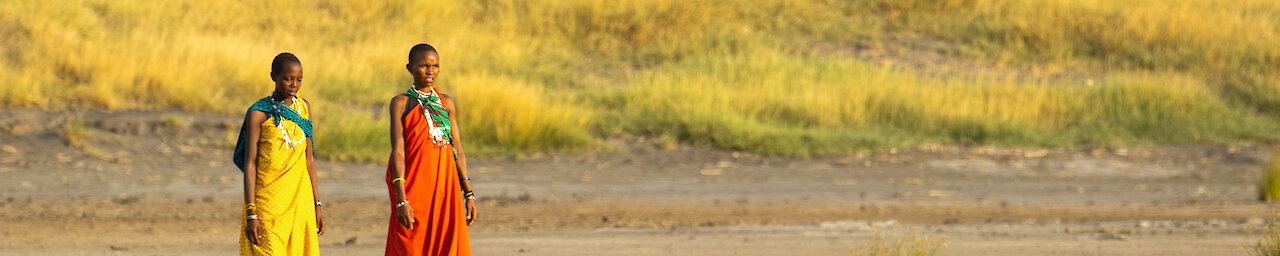 Zwei Massai Frauen laufen durch die Savanne