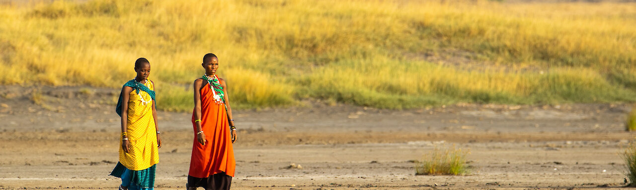 Zwei Massai Frauen laufen durch die Savanne