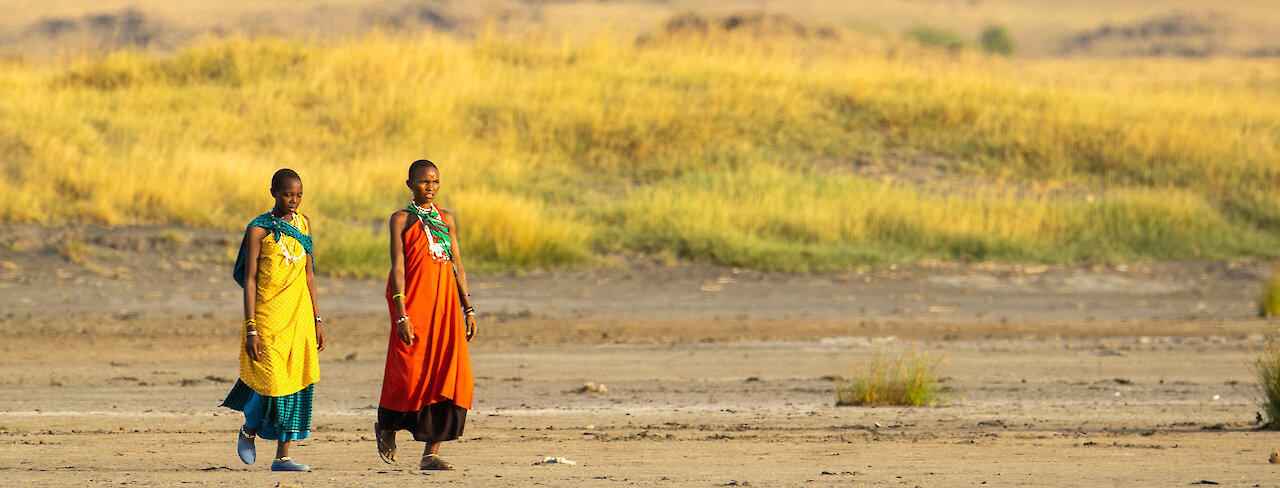 Zwei Massai Frauen laufen durch die Savanne