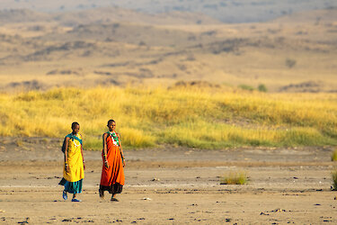 Zwei Massai Frauen laufen durch die Savanne