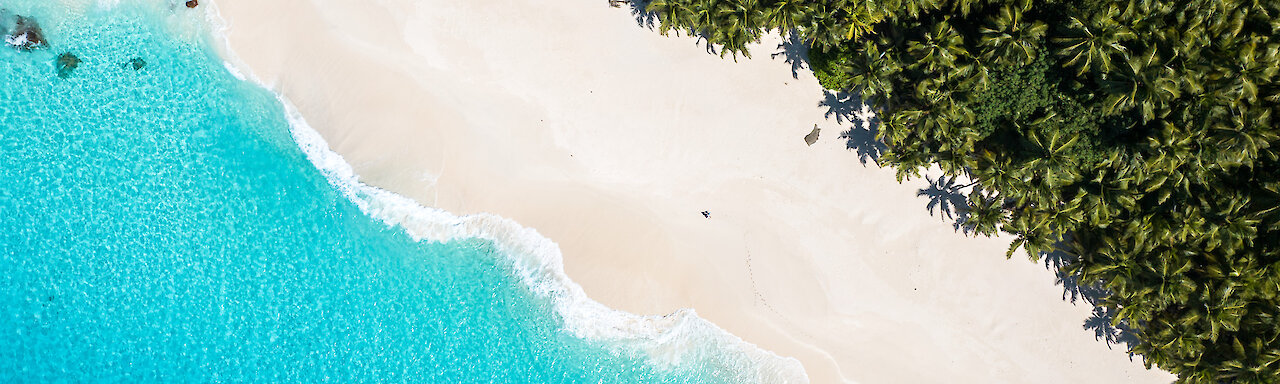 Luftaufnahme von weißem Sandstrand und türkisem Wasser