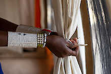 Maasai bindet Vorhang im Zelt von Lake Natron Camp