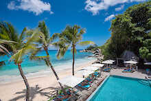 Gäste liegen am Pool des Carana Beach Hotels