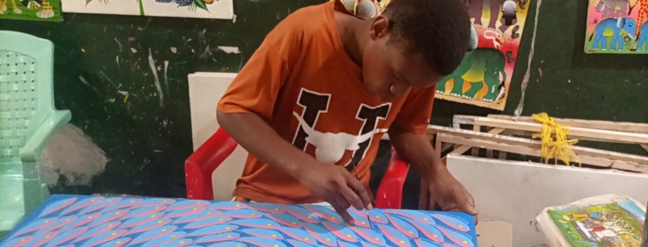 Ein junger Mann arbeitet an seinem Kunstwerk