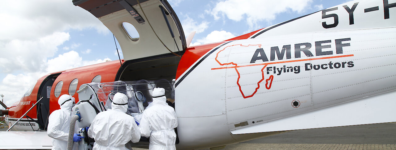 Das AMREF Team bei der Arbeit vor einem Flugzeug
