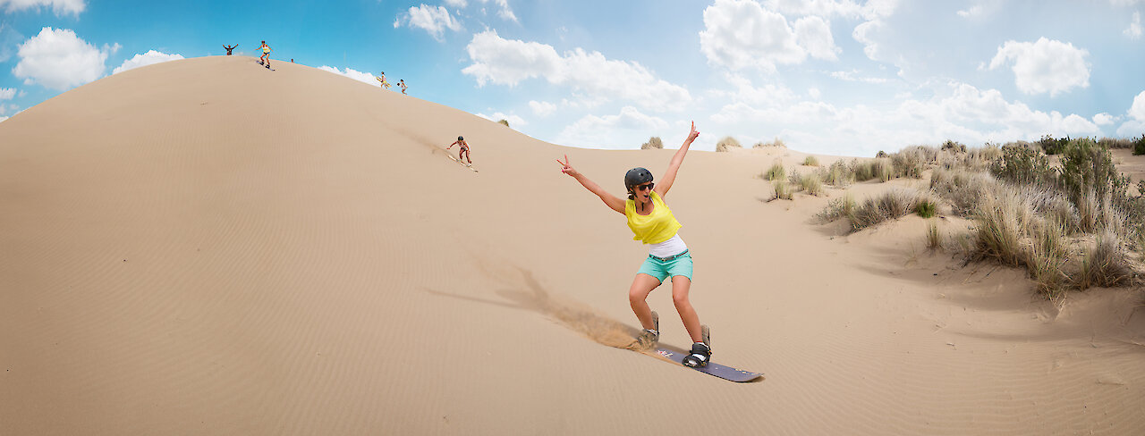 Eine freudige Frau beim Sandboarding