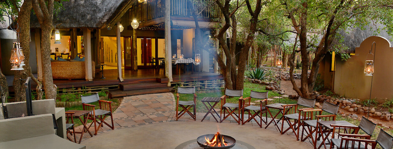 Außenansicht der Tambuti Lodge mit Lagerfeuer