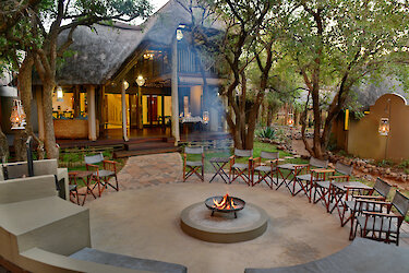 Außenansicht der Tambuti Lodge mit Lagerfeuer