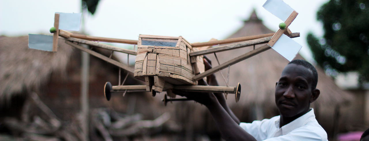 Mann zeigt sein selbst gebautes Modell-Flugzeug in der Elfenbeinküste