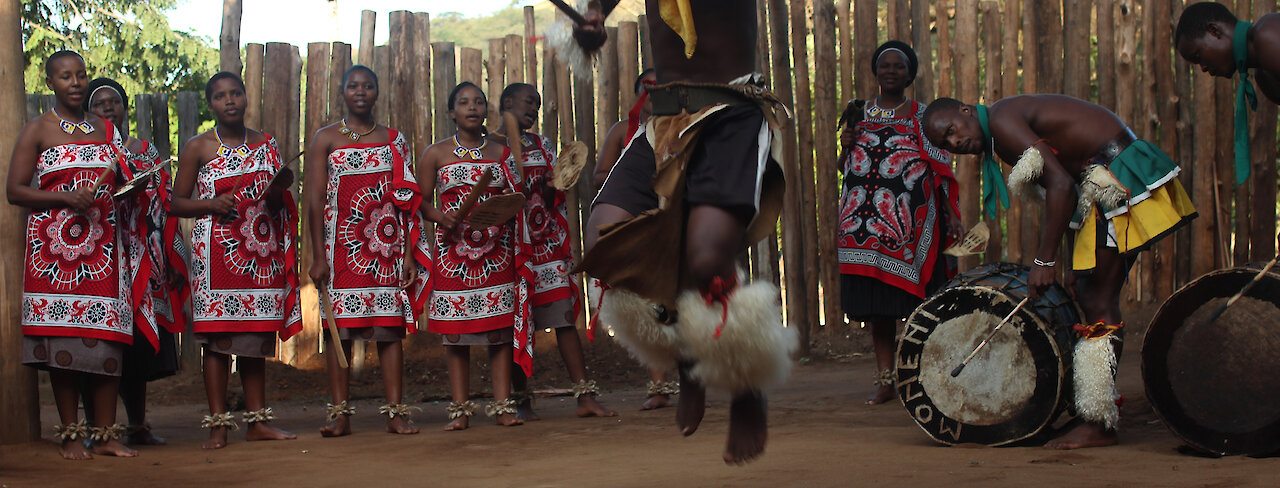 Die Einheimischen singen und tanzen in ihren traditionellen Kleidungen. eSwatini.